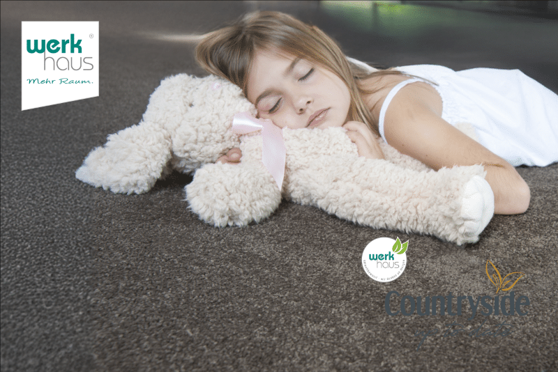 Kind schläft auf weichem Teppichboden mit Kuscheltier – werkhaus Countryside für gesundes Wohnen